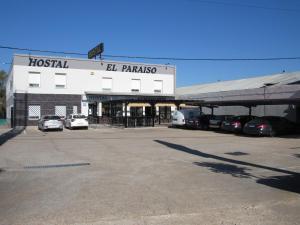 a building with cars parked in a parking lot at Hostal Restaurante el Paraíso in Don Benito