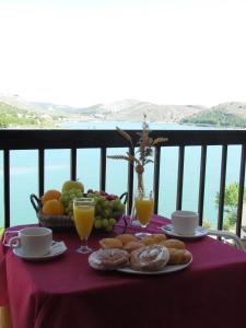 un tavolo con prodotti per la colazione e bevande su un balcone di Hostal Las Rumbas a Nuévalos