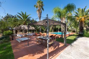 eine Terrasse mit einem Tisch und Stühlen neben einem Pool in der Unterkunft Villa with swimming pool Salento - Villa Le Due Sorelle in Ugento
