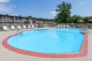 a large swimming pool at a hotel with chairs at Days Inn & Suites by Wyndham Lexington in Lexington