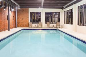 a swimming pool with blue water in a building at Ramada by Wyndham Alpharetta Atlanta North in Alpharetta