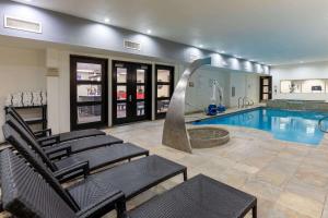 a pool with chairs and a fountain in a building at Hawthorn Suites by Wyndham Lubbock in Lubbock