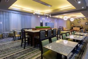 a restaurant with tables and chairs and a bar at La Quinta by Wyndham Houston NW Beltway8/WestRD in Houston