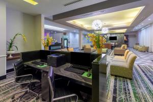 a lobby with a desk with a computer and chairs at La Quinta by Wyndham Houston NW Beltway8/WestRD in Houston