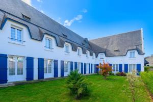 ein großes weißes Gebäude mit blauen Türen und einem Hof in der Unterkunft Quality Hotel La Marebaudière Vannes Centre in Vannes
