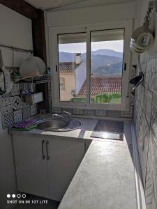 eine Küche mit einem Waschbecken und ein Fenster mit Aussicht in der Unterkunft apartamento genil in Granada