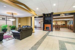 a lobby with a couch and a television and a table at Suburban Studios Buffalo Airport in Cheektowaga