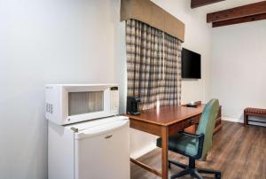 a kitchen with a table and a microwave on top of a refrigerator at Quality Inn - On The Lake Clarksville-Boydton in Clarksville