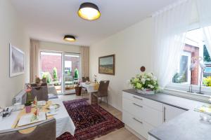 eine Küche und ein Esszimmer mit Tisch und Stühlen in der Unterkunft Hotel garni NordSeerose Greetsiel in Krummhörn
