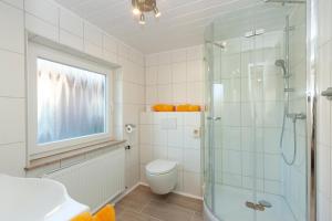 ein Badezimmer mit Toilette und Glasdusche in der Unterkunft Hotel garni NordSeerose Greetsiel in Krummhörn