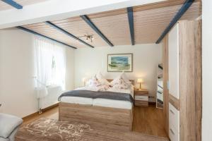 ein Schlafzimmer mit einem Bett und einer Holzdecke in der Unterkunft Hotel garni NordSeerose Greetsiel in Krummhörn