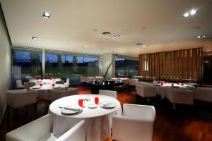 a restaurant with white tables and white chairs at Finca Prats Hotel Golf & Spa in Lleida