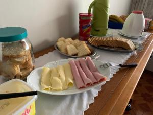 einen Tisch mit Käseplatten und Brot in der Unterkunft Casa de hospedagem providências in Cachoeira Paulista