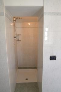 La salle de bains est pourvue d'une douche et d'une baignoire. dans l'établissement Villa Chiara Hotel, à Canelli