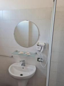 La salle de bains est pourvue d'un lavabo et d'un miroir. dans l'établissement LA PALAZZINA, à Rome