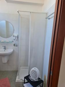 La salle de bains est pourvue d'une douche, d'un lavabo et d'un ventilateur. dans l'établissement LA PALAZZINA, à Rome