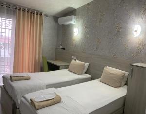 a hotel room with two beds and a window at Eurolux Boutique-Hotel in Tashkent