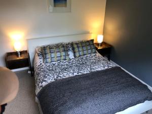 a bedroom with a bed with two lamps on two tables at Beach Road- short walk to Charlestown, Carlyon Bay & coastal paths in Carlyon Bay