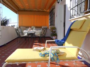 een gele stoel op een balkon met een tafel bij Apartamento Playa de Regla, Chipiona, Andalucía, Aire acondicionado, Garaje, Wifi, Terraza in Chipiona