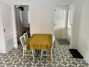 a room with a table with chairs and a checkerboard floor at Fjällnära Stuga i Jämtland in Svenstavik +2 photos