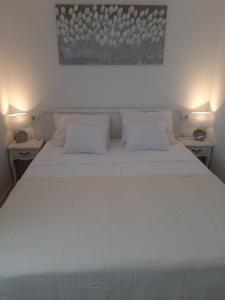 Gita Apartmani في سيزيتشي: غرفة نوم بسرير ابيض مع وسادتين