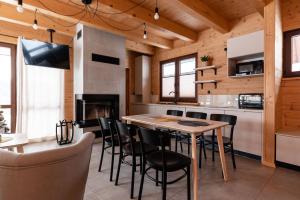 a kitchen with a table and chairs and a fireplace at Willa Żar in Bialskie