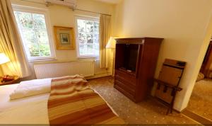 a bedroom with a bed and a flat screen tv at Waldhotel Silbermühle in Horn-Bad Meinberg