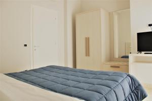 a bedroom with a blue blanket on a bed at Zibibbo Beach Apartments - Trapani in Trapani