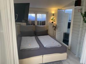 ein Bett mit zwei Kissen auf einem Zimmer in der Unterkunft Holzhaus Leverkusen in Leverkusen
