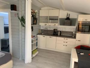 a kitchen with white cabinets and a counter top at Holzhaus Leverkusen in Leverkusen