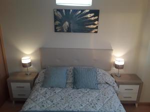 1 dormitorio con 1 cama con 2 mesitas de noche y 2 lámparas en Apartamento de 6 personas con WIFI Y GARAJE INCLUIDO en Valladolid