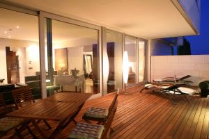 a wooden deck with a table and chairs on it at Finca Prats Hotel Golf & Spa in Lleida