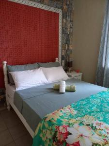 a bedroom with a bed with a red wall at Vacances Le Nereide Blue Bay in Blue Bay