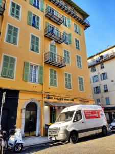 una furgoneta estacionada frente a un edificio amarillo en 2 à 6 personnes - WELCOME TO NICE ! LOGEMENT PORT, en Niza