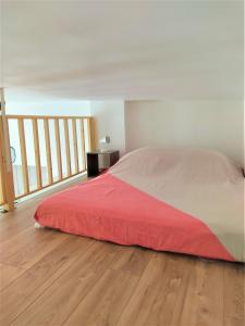 1 dormitorio con 1 cama con manta roja en el suelo de madera en 2 à 6 personnes - WELCOME TO NICE ! LOGEMENT PORT, en Niza