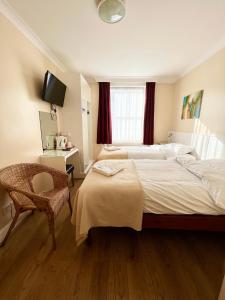 倫敦的住宿－墨爾本別墅酒店，酒店客房设有两张床和电视。