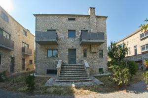 a brick building with stairs in front of it at Kalpaki stone apartment 1 in Kalpákion
