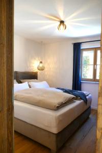 - une chambre avec un grand lit et un ventilateur de plafond dans l'établissement Ferienwohnung Goller, à Lenggries