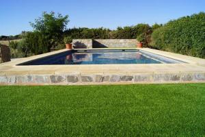 a swimming pool in a yard with green grass at Casa Rural Recreo in El Gastor
