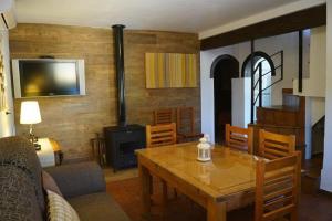 a living room with a table and a stove at Casa Rural Recreo in El Gastor