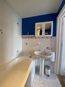 un baño con bañera y lavabo en Pound Corner, en Godalming 42 fotos más