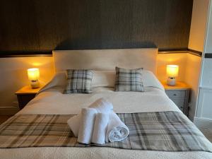 ein Schlafzimmer mit einem Bett mit zwei Handtüchern darauf in der Unterkunft The Royal Oak Inn in Bowness-on-Windermere