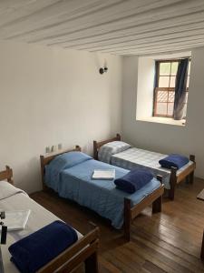 um quarto com três camas e uma janela em Pousada Vila Rica em Ouro Preto