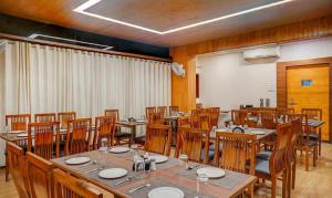 a dining room with wooden tables and chairs at Hotel Shiva's, Kolhapur in Kolhapur