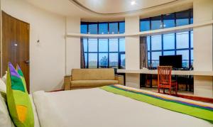 a bedroom with a bed and a desk with a computer at Hotel Shivas Inn in Kolhapur