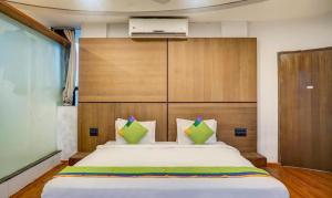 a bedroom with a large bed with a wooden headboard at Hotel Shiva's, Kolhapur in Kolhapur