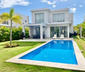 una casa con piscina frente a ella en Villa Real Playa Nueva Romana en La Romana