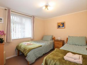 - une chambre avec 2 lits et une fenêtre dans l'établissement Robin's Nest, à Windermere