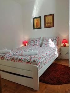 1 dormitorio con cama blanca y alfombra roja en SRNA APARTMAN, en Vrnjačka Banja