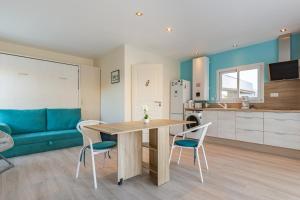 Una cocina y una sala de estar con mesa y sillas. en Manava, en Vaux-sur-Mer